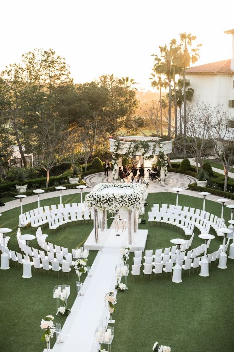 wedding chairs with white covers at an outdoor ceremony