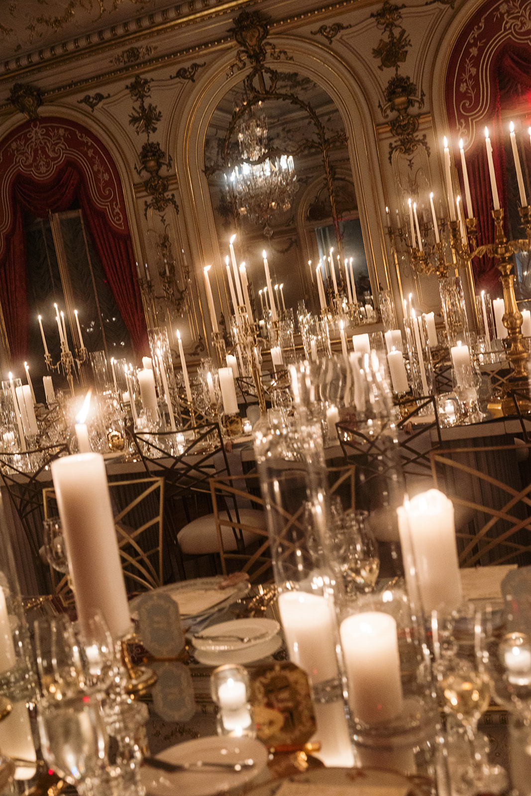Dramatic tiered taper candles reflecting on mirrored tables with patented Fanfare frames.
